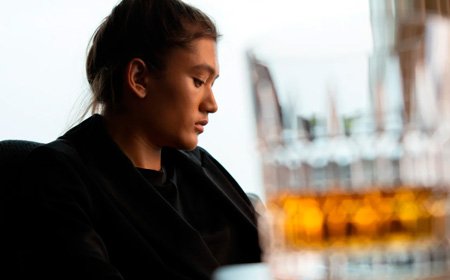 Стакан алкоголя на фоне женщины